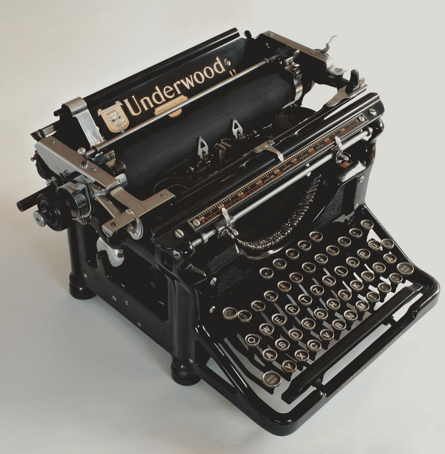 a photo of a restored Underwood typewriter. its mechanism is big, but the keyboard is quite compact. the typewriter square,is clean, black and glossy, has a German QWERTY layout, and looks like it was just made.